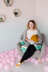 young woman sitting on chair and holding merino wool in hands
