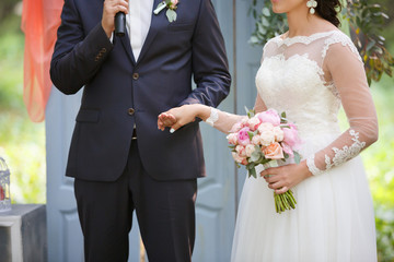 newlyweds swear fidelity at wedding ceremony outdoors. Wedding day