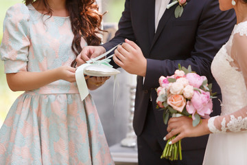 groom dresses a ring on a finger to the bride on wedding registration outdoors