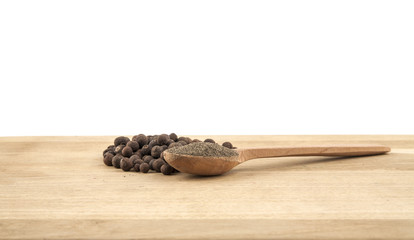 allspice in a wooden spoon on the wood table