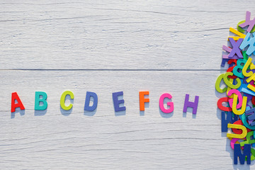 Colorful wooden alphabet. Top view on white wooden