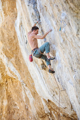 Rock climber on challenging route on cliff