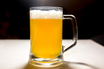 Glass of light beer with foam closeup