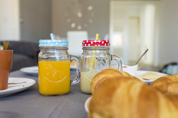 close up view of a  breakfast for two. orange  juice, croissants, coffee and tea