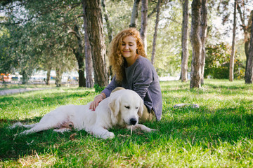 Young female playing with labrador retriever dog in park