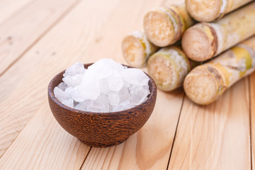 Rock sugar and sugar cane on wooden table background