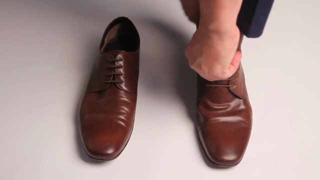 Man dresses brown shoes