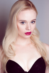 Beauty model girl with perfect make-up red lips and blue eyes looking at camera, wearing magenta bra. Portrait of attractive sexy young woman with blond hair. 