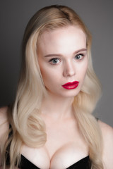 Fototapeta premium Beauty model girl with perfect make-up red lips and blue eyes looking at camera, wearing magenta bra. Portrait of attractive sexy young woman with blond hair. 