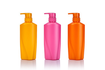 Blank yellow, pink and orange plastic pump bottle used for shampoo or soap. Studio shot isolated on white