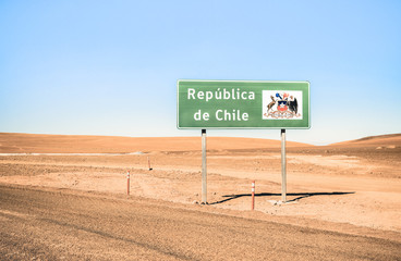 Border sign of  " Republica de Chile " on desert crossing road on way to Bolivia through Atacama desert mountains - Adventure travel concept to south american exclsuive destination on retro filter