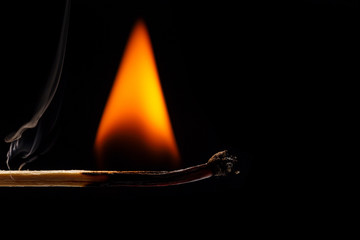 Macro fire burning on matchstick. Studio shot isolated on black