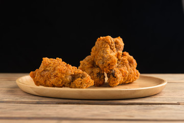 Fried chicken on  wood dish with black background.