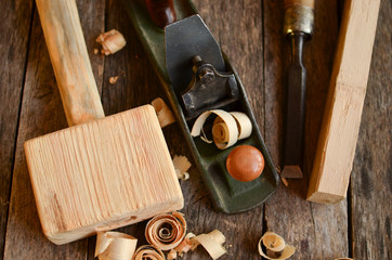 Old carpentry tools hammer, chisel, plane on an old board