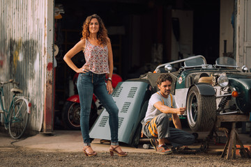 Beautiful girl in red dress in a car workshop