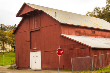 Old Red Barn In Town With Red Roof