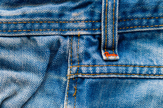 Denim Pants Elements as Background. Detail of jeans trousers close-up. Pockets, pants, belt loops, thick stitches. Elements of denim pants background