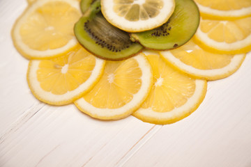 Pieces of kiwi and lemon on a wooden background