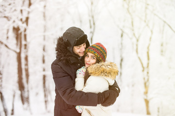 Young couple hugging by the river in winter weather