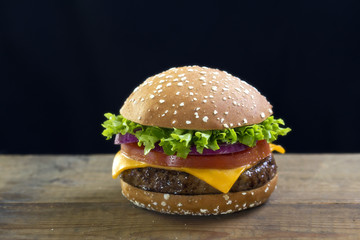 Burger with cheese, lettuce, tomato and red onion