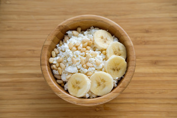 Healthy eating. Cottage cheese with banana and pine nuts.