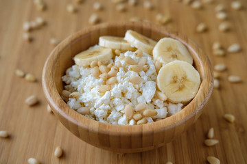 Healthy eating. Cottage cheese with banana and pine nuts.