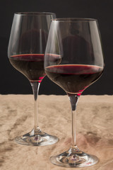 Two glasses of red wine on black background