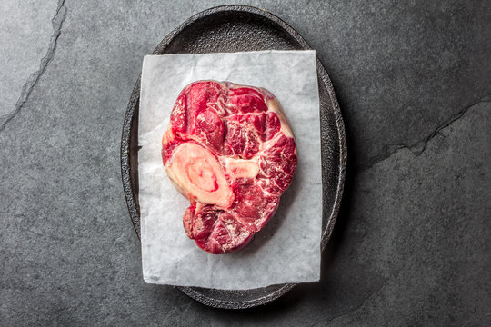 Raw osso buco veal shank on slate background. Top view