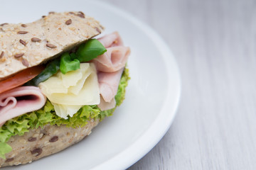 Baguette sandwich with ham, cheese, tomatoes and lettuce. Close up