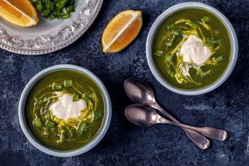 Bowls with green soup of broccoli, spinach