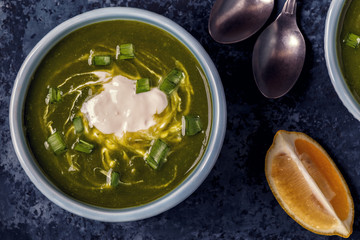 Bowls with green soup of broccoli, spinach