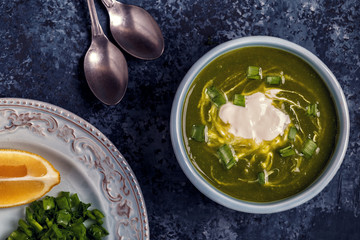 Bowls with green soup of broccoli, spinach