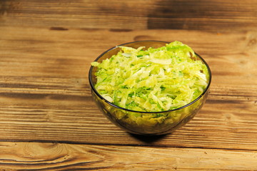 Savoy cabbage salad in glass bowl on wooden table