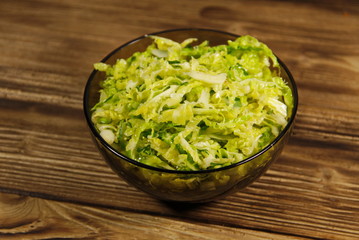 Savoy cabbage salad in glass bowl on wooden table