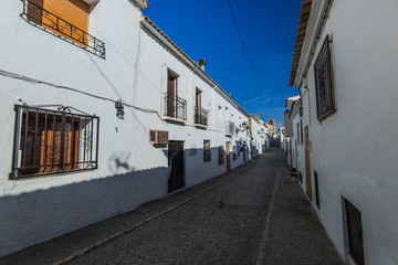 narrow street with white houses in Spain