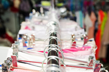 Beautiful warm colorful sweaters hang on hangers inside a clothing store. Beautiful clothes for the winter autumn season.