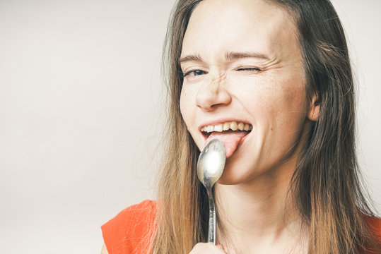 Hungry woman eating spoon