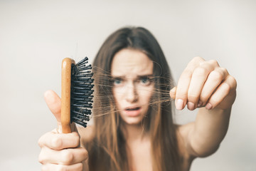 Woman with hair comb loss hairs close up