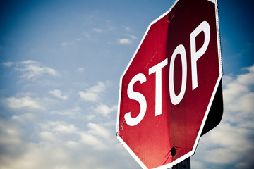 close up of a uniquely bent stop sign with sky in background