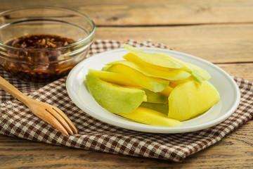 Mango-with-sweet-fish-sauce on wood table.