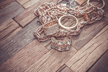 Beautiful golden jewelry on wooden background. Macro shot.