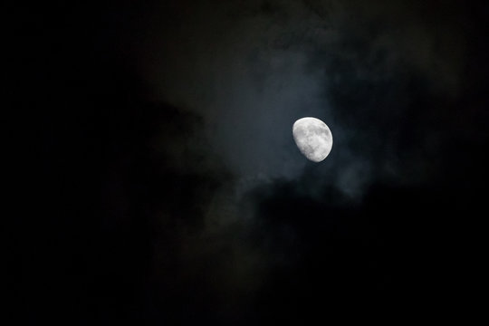 Moon in the clouds in the dark sky