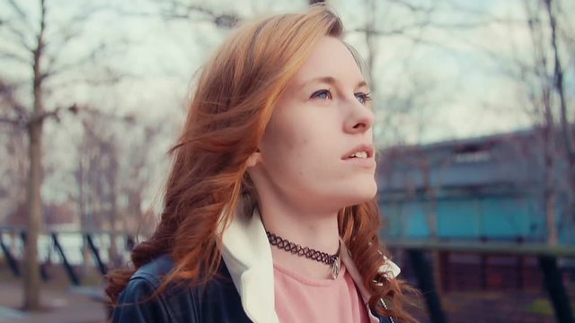 Young woman in park looking into the sky in slow motion