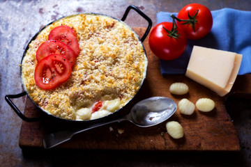 Cheese macaroni bake with tomatoes and gnocchis