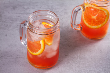 Orange cocktail garnished with thyme in jars