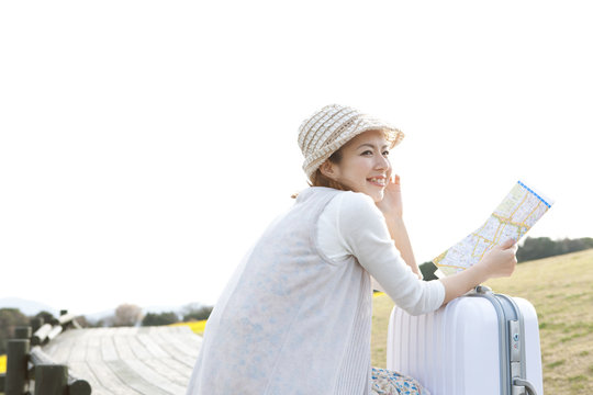 Young woman with map and suitcase