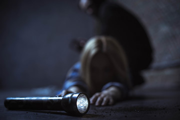 Weak blonde woman trying reaching a flashlight