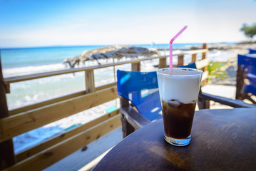 Have a little break. Delicious frappe on the beach bar with sea view. Summer vacation