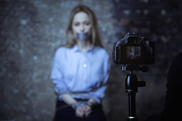 Mute powerless woman sitting in front of camera