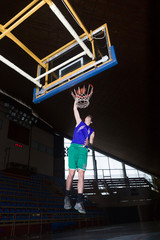 basketball player drum basket in basketball court in sports hall